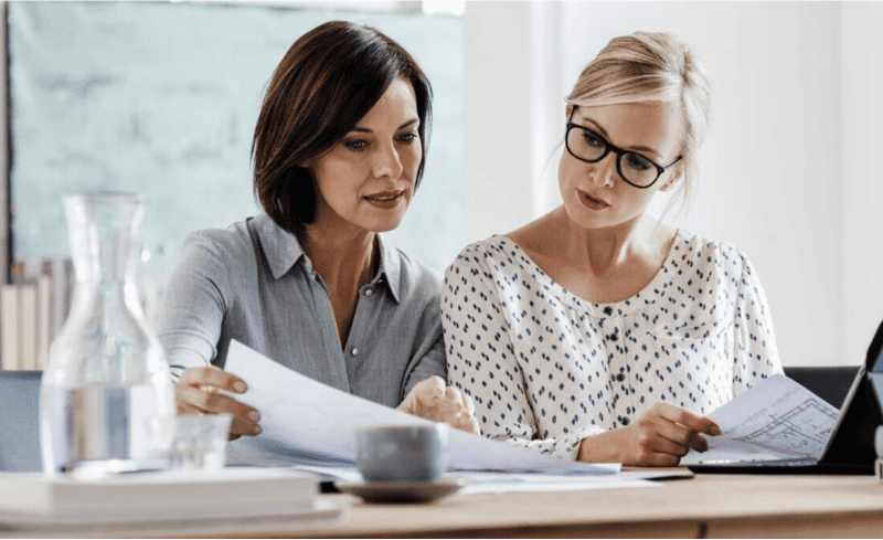 Zwei Frauen, die sich Bewerbungsunterlagen anschauen