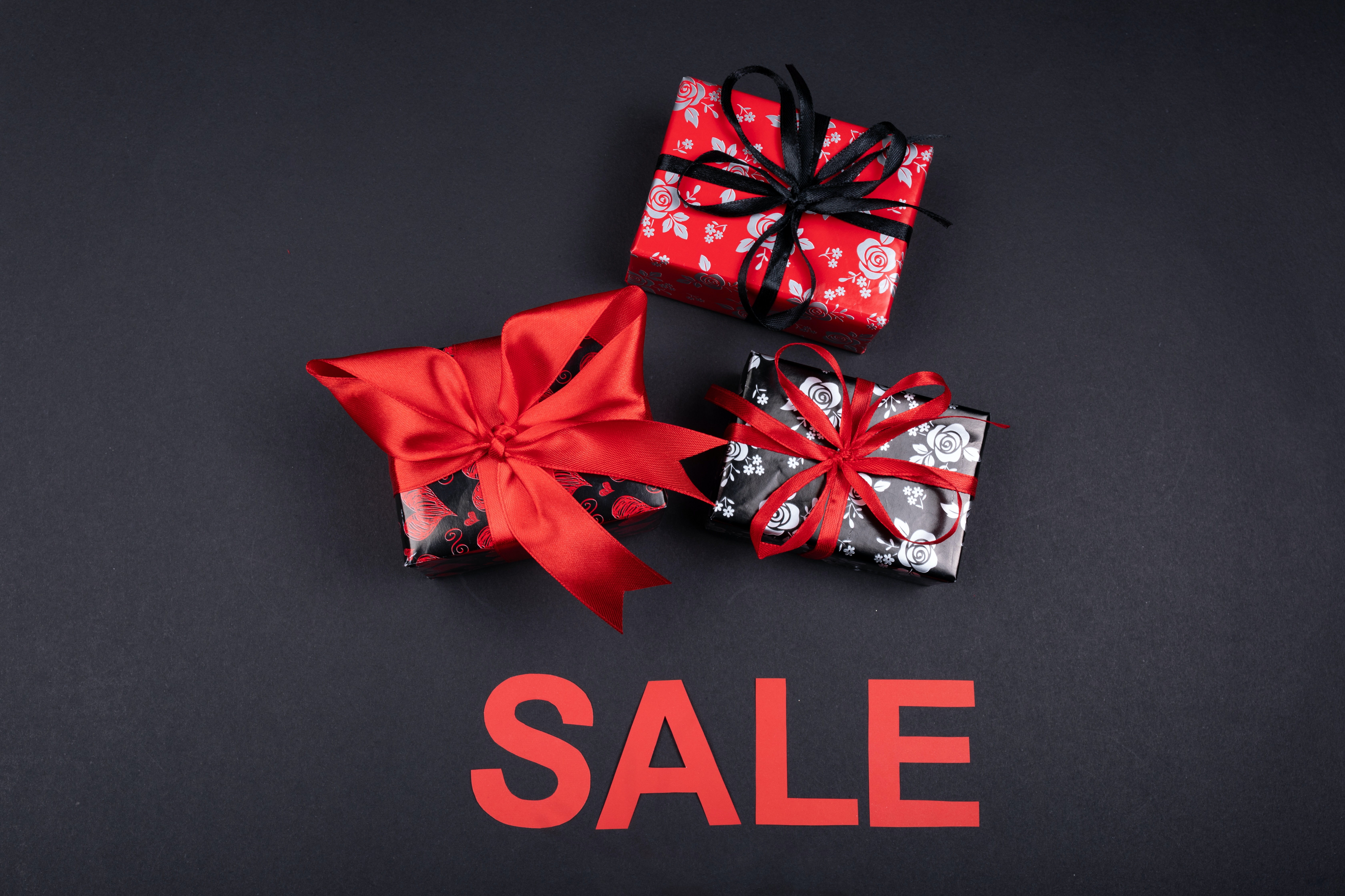 Geschenke und das Wort SALE auf schwarzen Hintergrund
