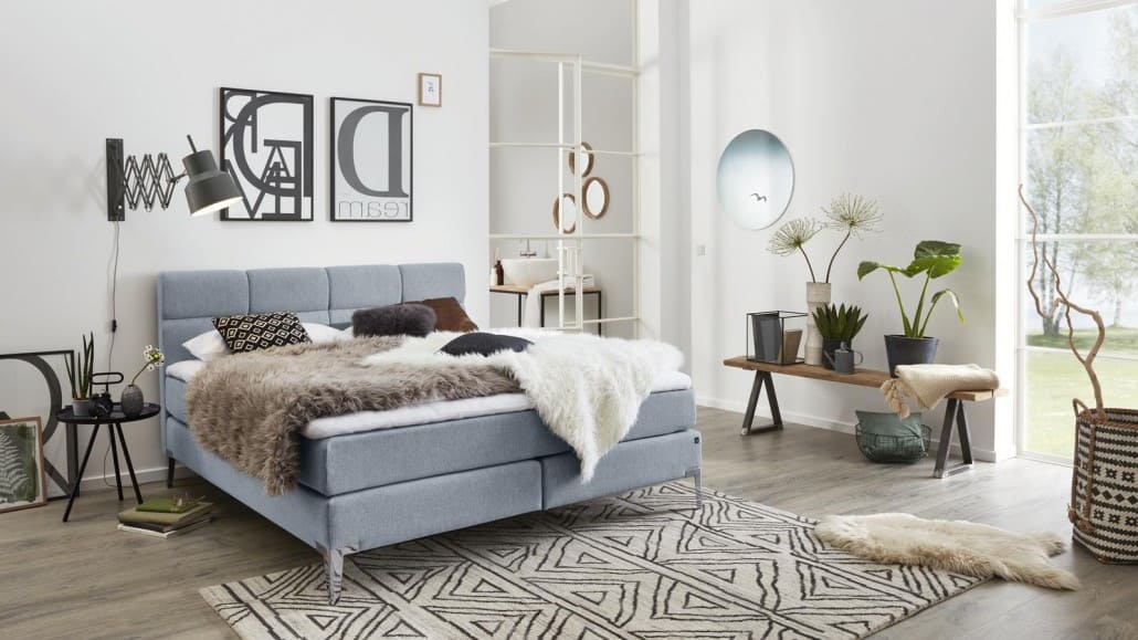 Boxspringbett in Grau in einem urban eingerichteten Zimmer