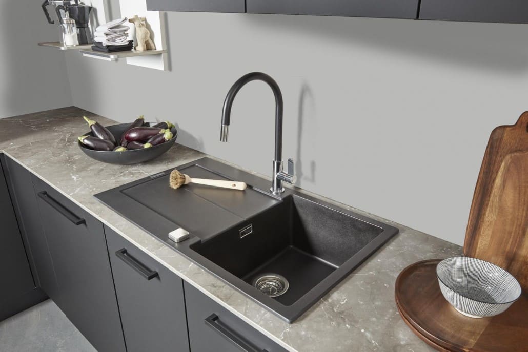 Schwarze, moderne Spüle in einer grauen Küche