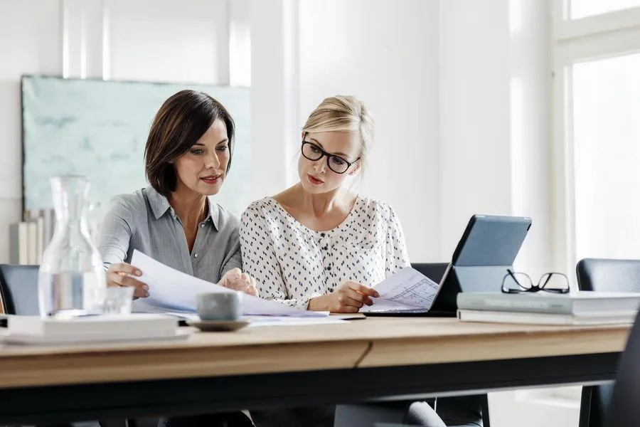 Zwei Frauen sehen sich im Büro einen Plan an
