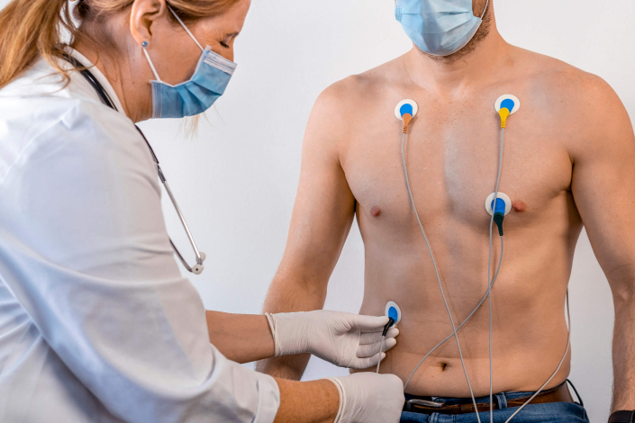 Ärztin führt eine Cardisiographie Untersuchung an einem Mann durch