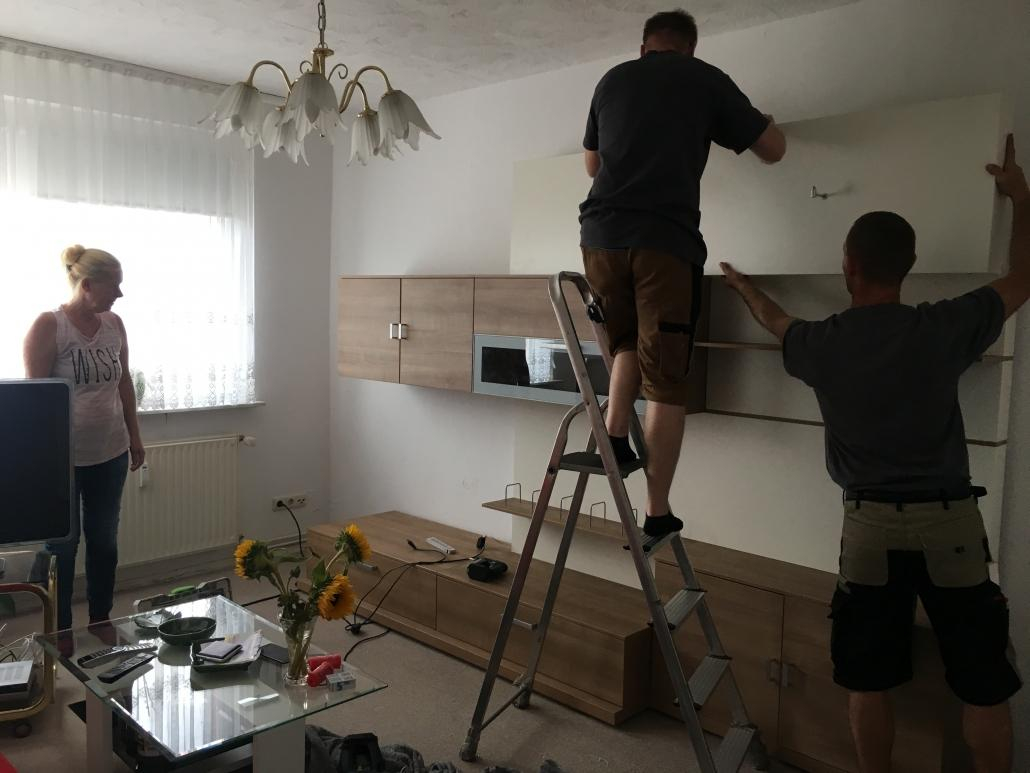 Monteure bauen Wohnwand im Wohnzimmer ein