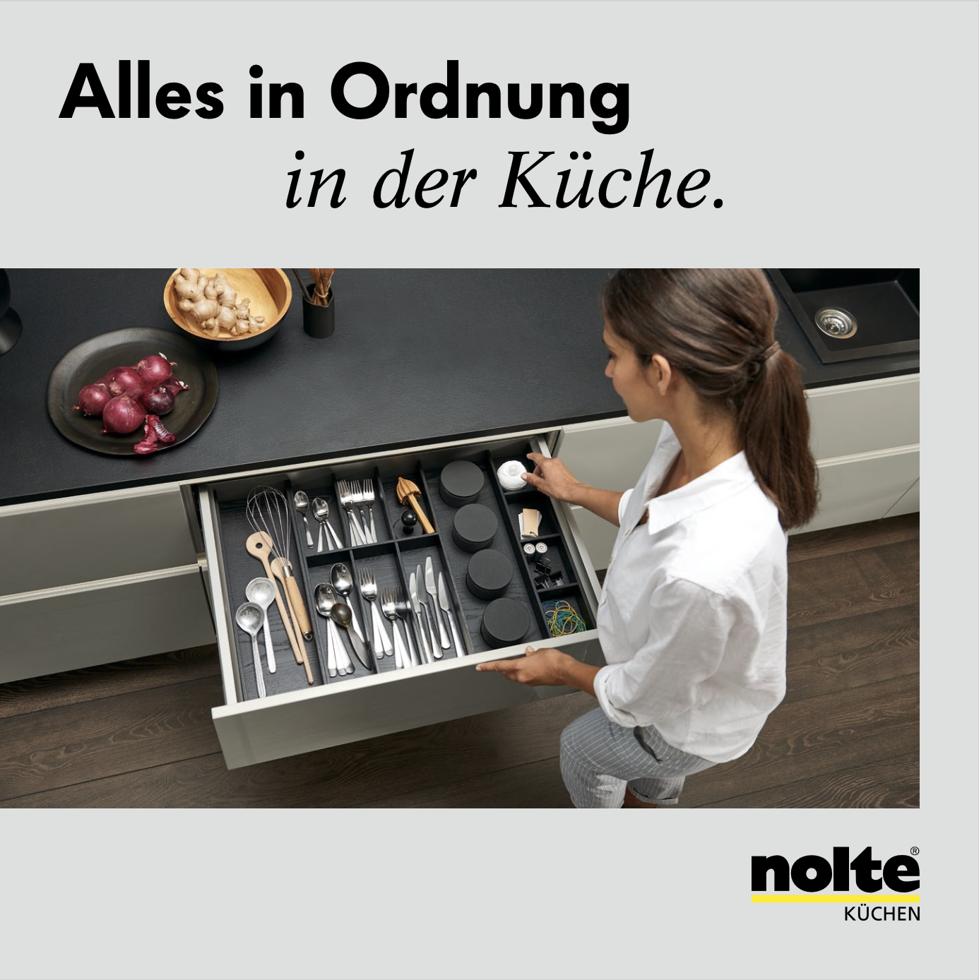 Text "Alles in Ordnung", im Hintergrund eine Frau, die sorgfältig etwas in eine Küchenschublade räumt