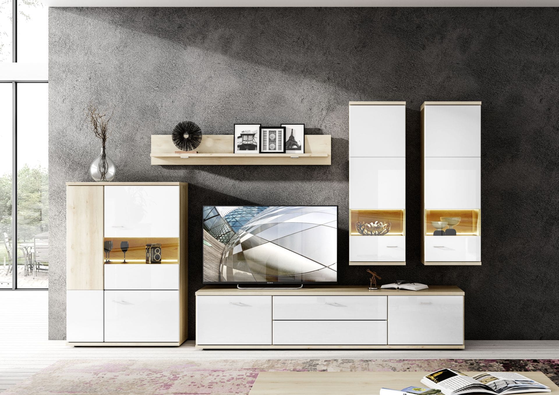 Wohnwand von vorne zu sehen, in weiss und hellbraune Holzdetails, vor Dunkelgrauer Wand