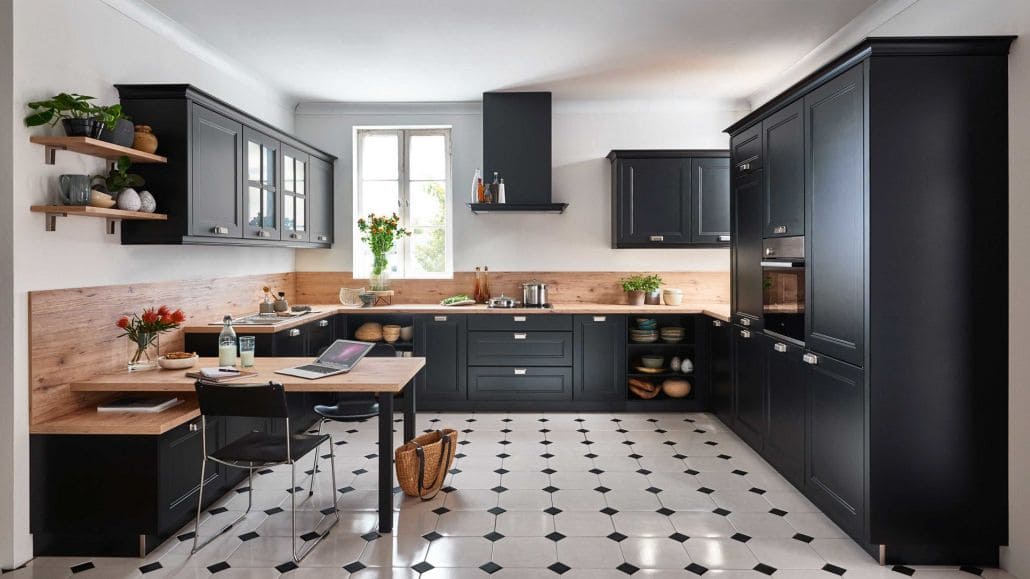 Landhausküche in schwarz, mit holzfarbigen Arbeitsplatten