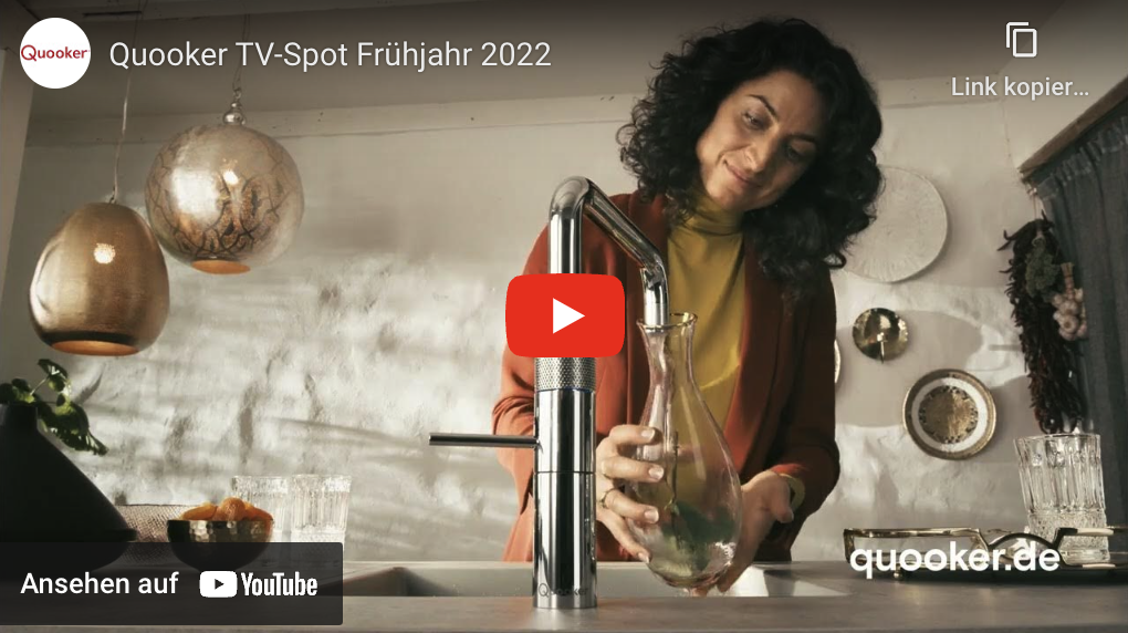 Frau holt sich Wasser aus ihrem Quooker