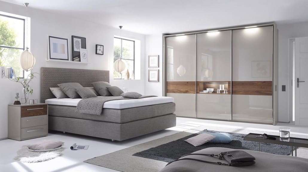 Boxspringbett vor einem Hochglanzoptik-Wandschrank