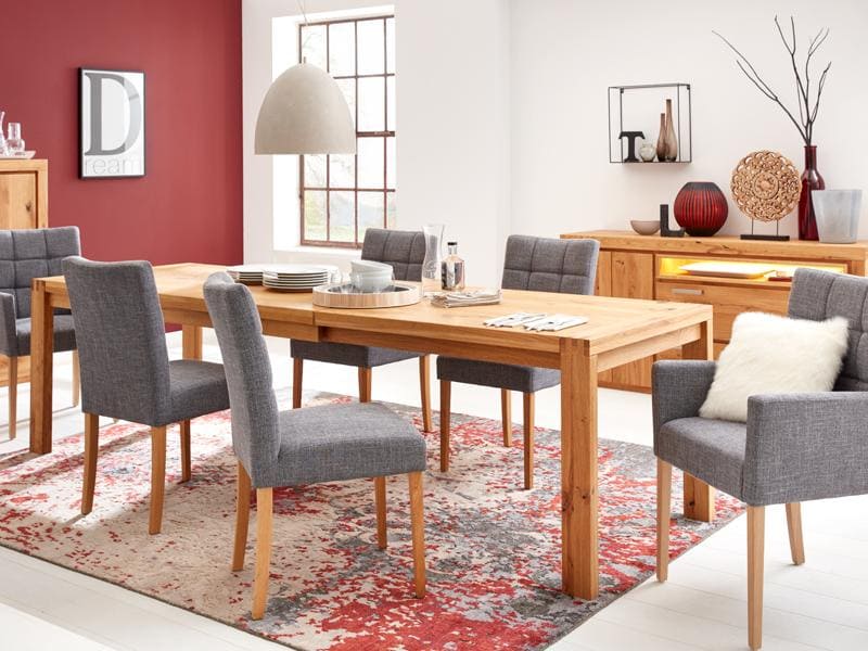 Esszimmer in der Mitte steht ein braunen Holztisch und grauen Stühlen drumherum 