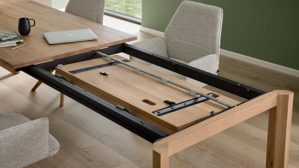 Auszugtisch von Interliving aus hellem Holz, der gerade ausgezogen wird