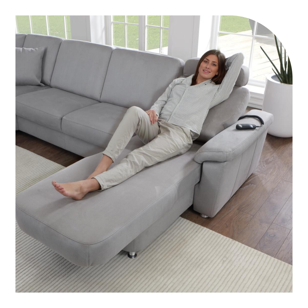 Frau liegt auf einem grauen Sofa