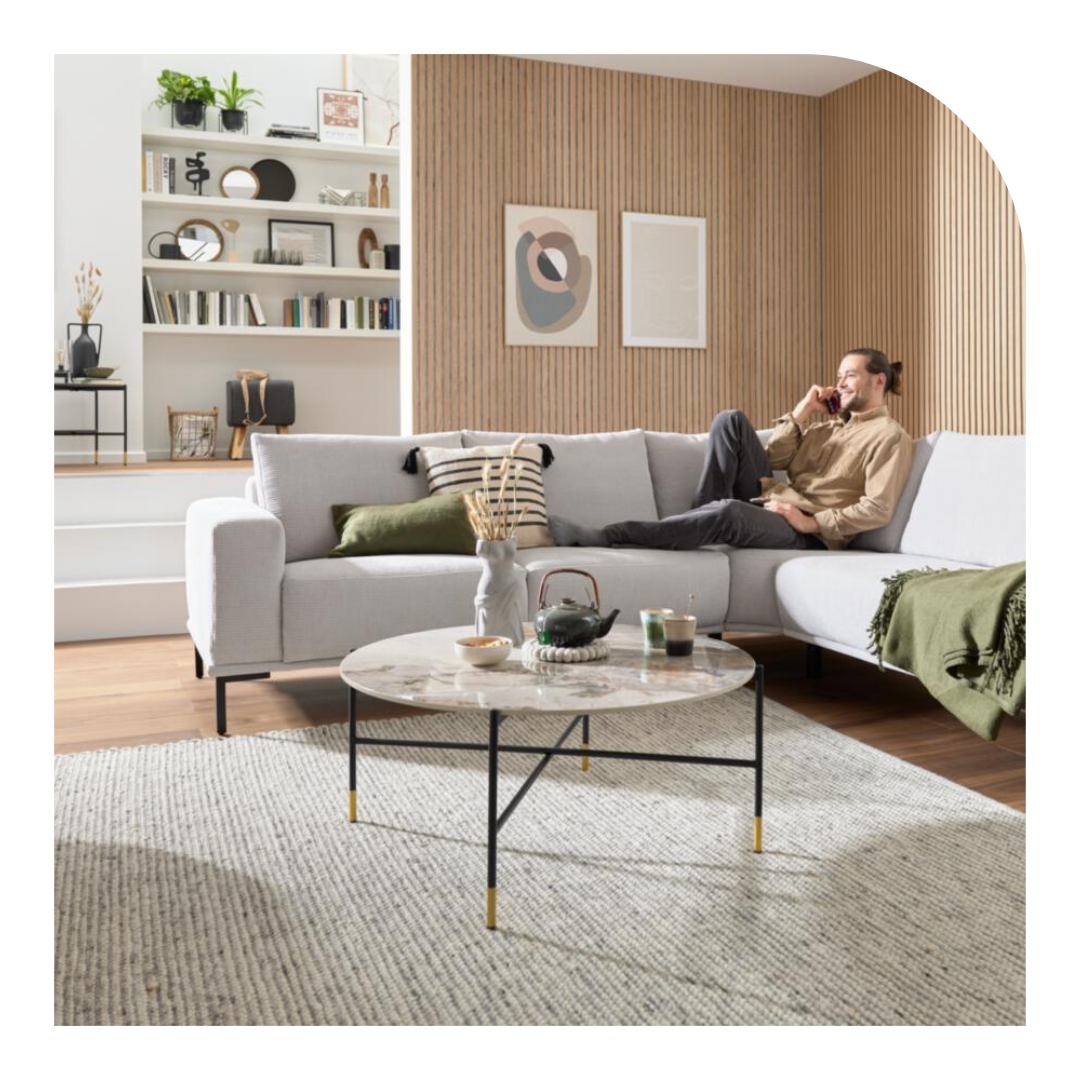 Mann telefoniert auf einem weißen Sofa