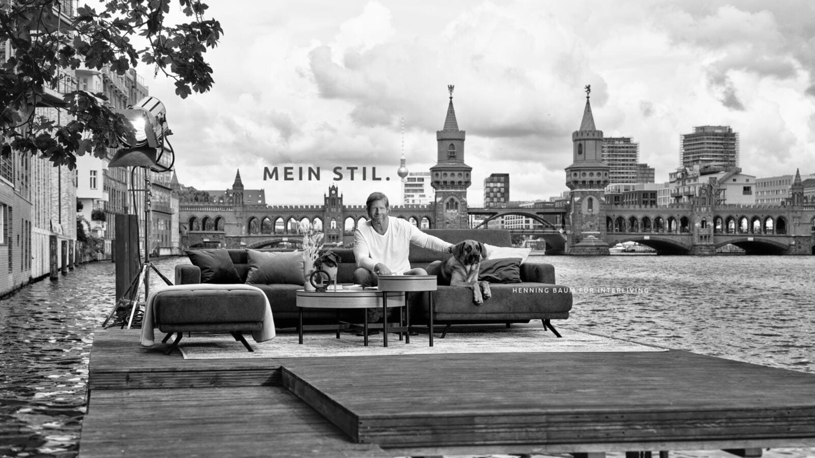 Schwarz Weiss Abbildung von Interliving, mit Henning Baum auf einem Sofa