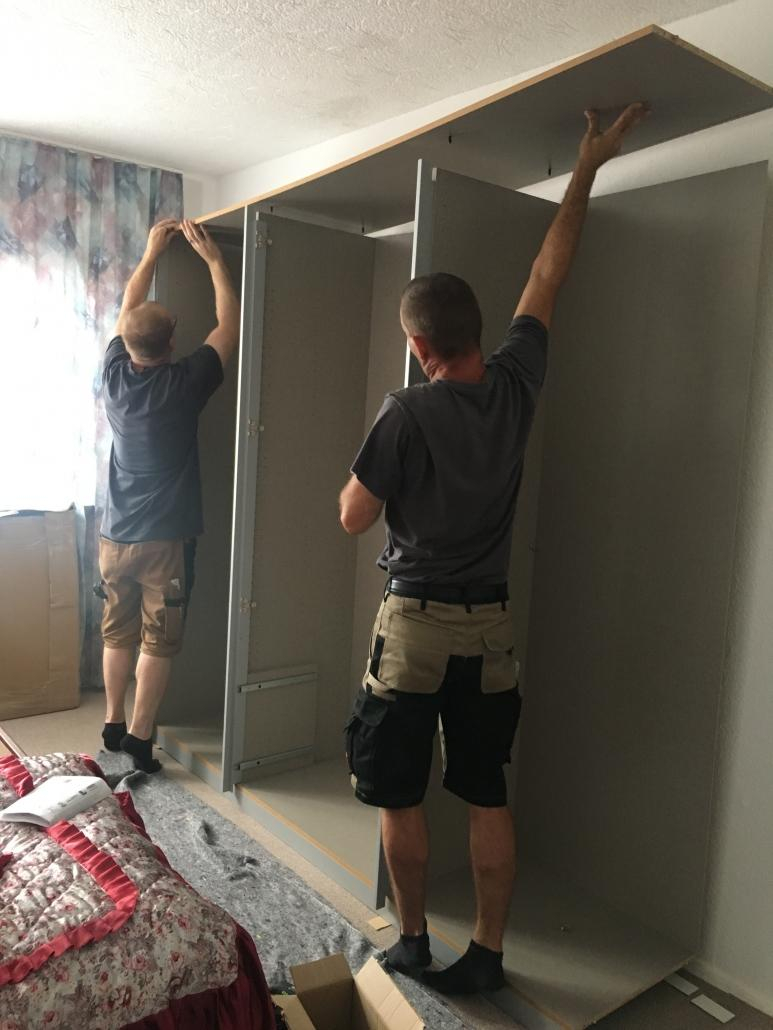 Zwei Monteure bauen einen Schrank auf
