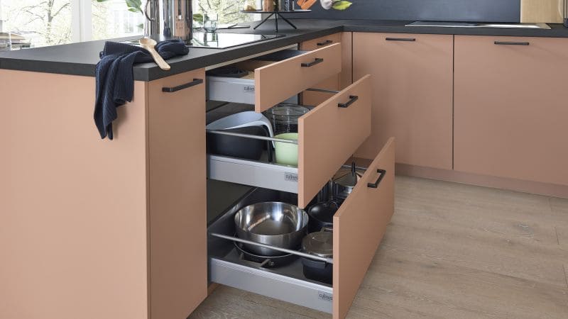 Hell orangene Küche, mit schwarzen Arbeitsplatten und schwarzen Griffen