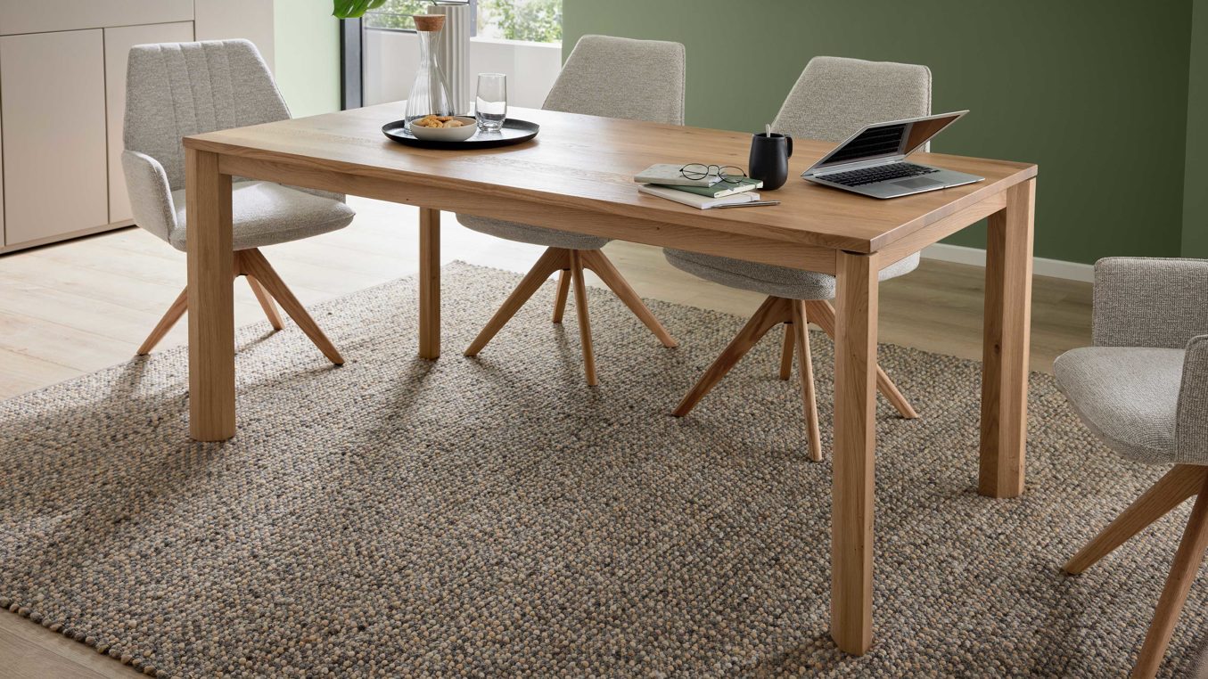 Auszugtisch von Interliving aus hellem Holz, daran stehen helle Stühle