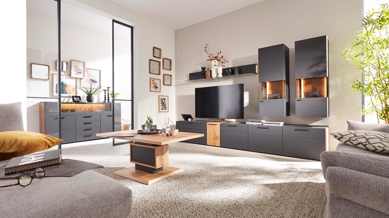 Wohnwand in einem matten Grau mit Holzdetails in einem hellen Wohnzimmer