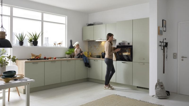 Mindgrüne Eckküche mit Frau und ihrem Kind