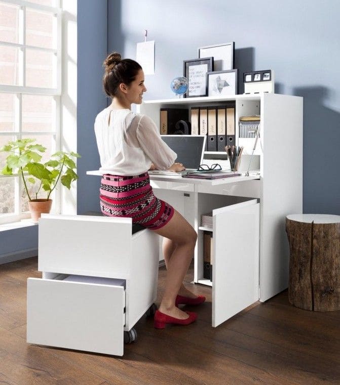 Schreibtisch, an welchem eine Frau sitzt