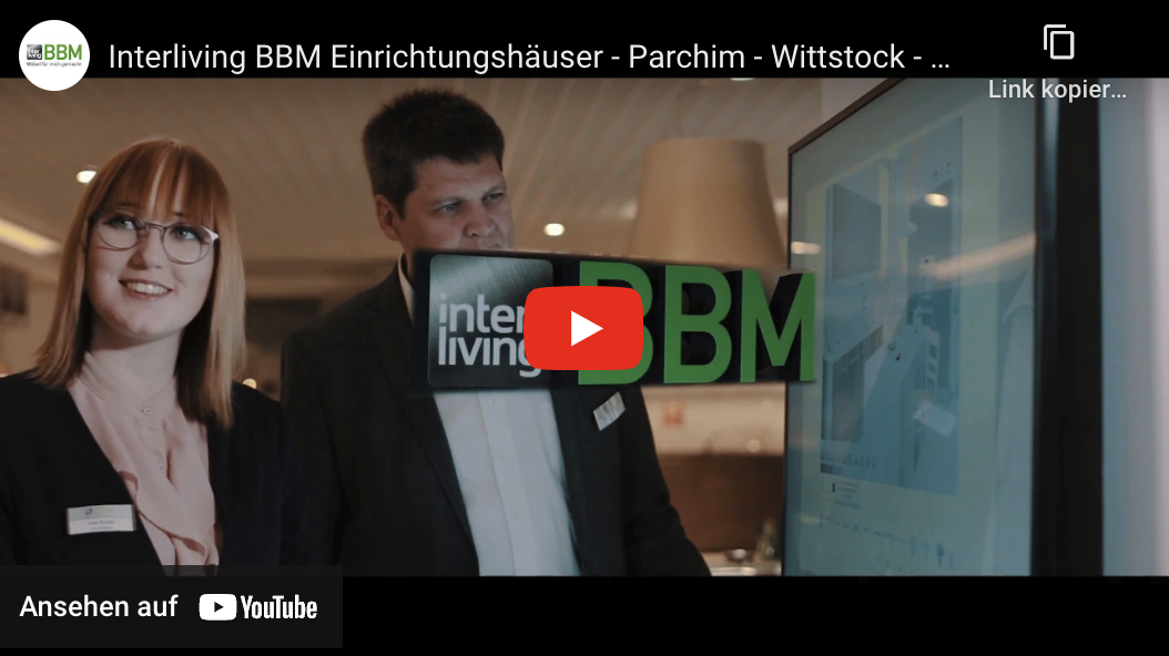 Mann und Frau hinter einer Glastür, auf welcher BBM steht