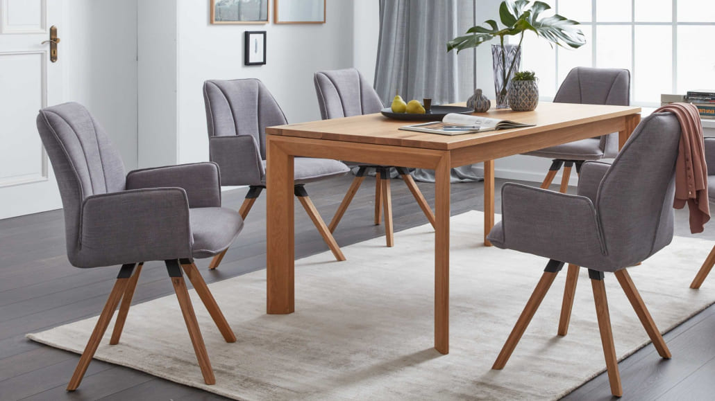 Esszimmertisch in dunkler Holzoptik mit grauen Esszimmerstühlen aus Stoff