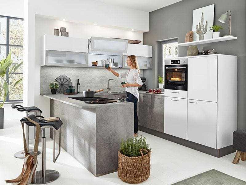 Moderne Küche, U-Form in grau und weiß, Frau steht in dieser Küche