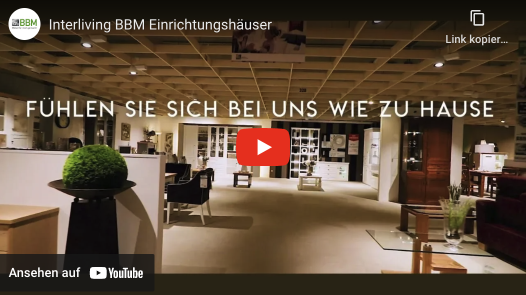 Text "Fühlen Sie sich bei uns wie Zuhause" über einem Ausstellunsgraum